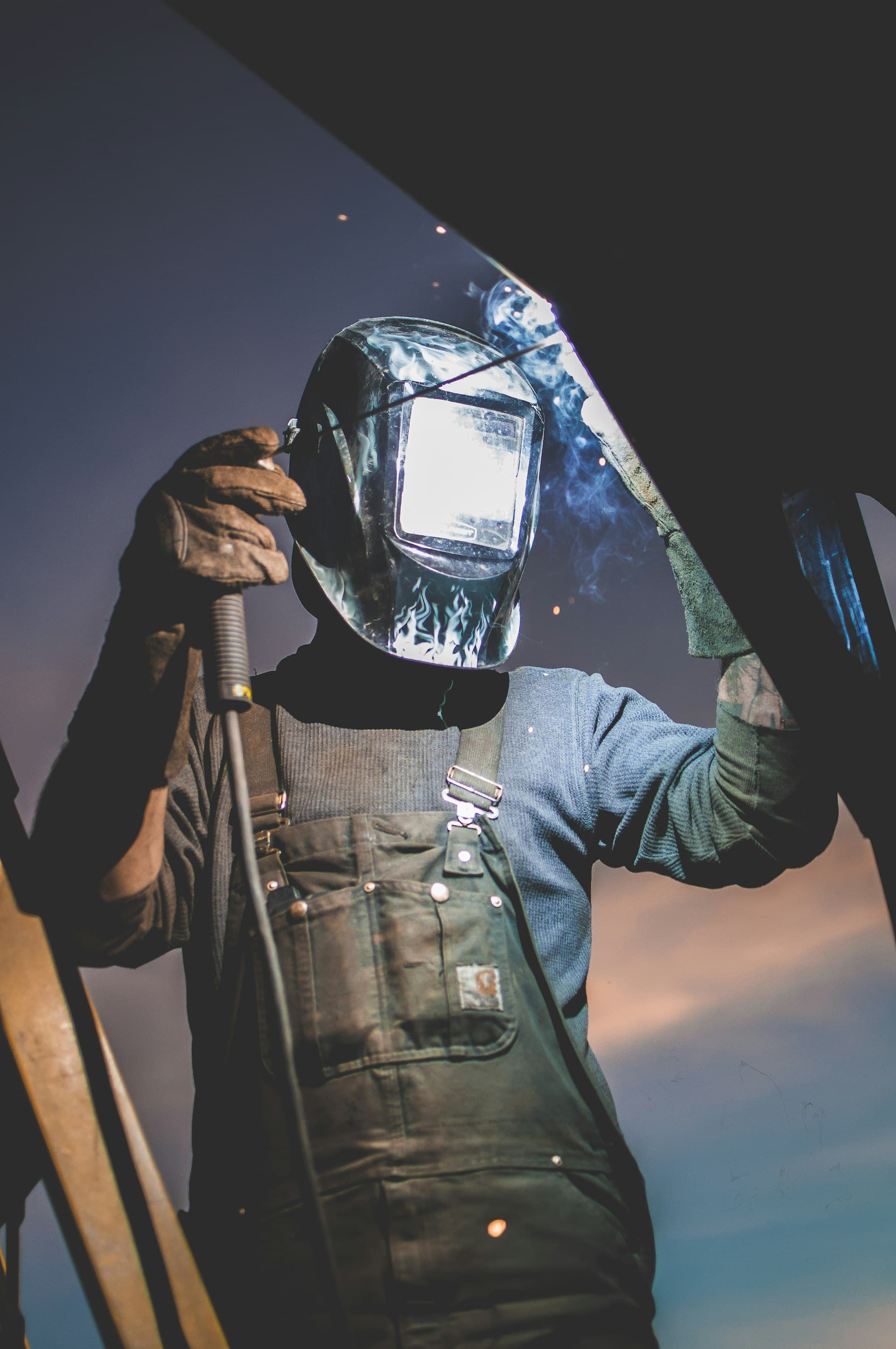 A welder in a darkening helmet at work